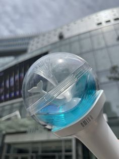 a close up of a blue and white object in front of a building with a sky background