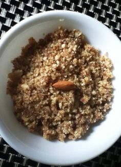 a white bowl filled with granola on top of a black and white table cloth