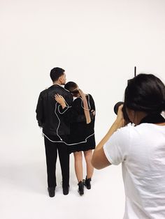 three people standing in front of a white background