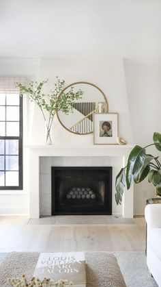 a living room with a fireplace and pictures on the wall