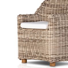 a wicker chair with white cushion and wooden legs