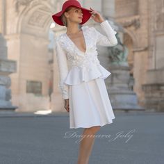 a woman wearing a white dress and red hat