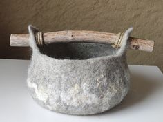 a gray felt basket with a wooden handle