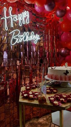 a birthday cake on a table with balloons and streamers in front of it that says happy birthday