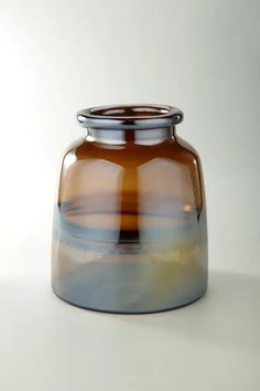 a brown glass vase sitting on top of a white table