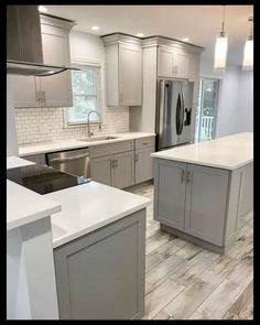 a kitchen with white counter tops and gray cabinets