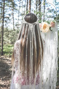 the back of a woman's head with long hair and flowers in her hair