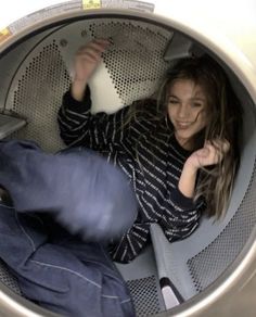 a woman is sitting in a washing machine