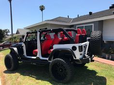 a white jeep with red seats is parked in front of a house and palm trees