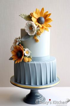 a blue and white cake with sunflowers on top