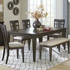 a dining room table with chairs and a bench