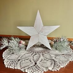 a white wooden star sitting on top of a doily