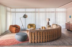 a living room filled with furniture next to a window covered in sheered drapes