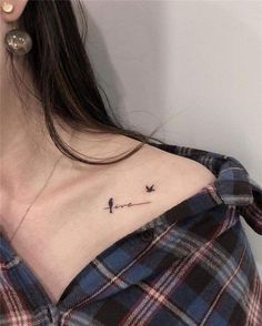 a woman with a small tattoo on her chest that has birds flying in the sky