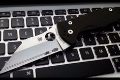 a knife sitting on top of a computer keyboard