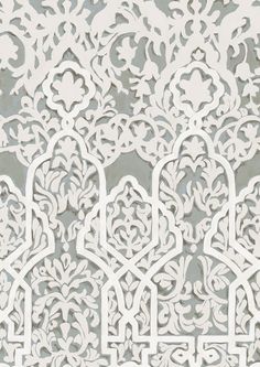 an intricate white lace pattern on a gray background