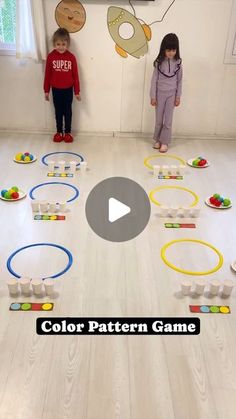 two young children standing in front of a colorful pattern game