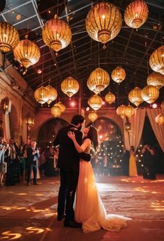 a bride and groom sharing their first dance in front of an audience at a wedding