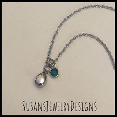 a necklace with two charms hanging from it's side on a white background that says susanswewerydesigns