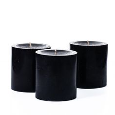 three black candles sitting next to each other