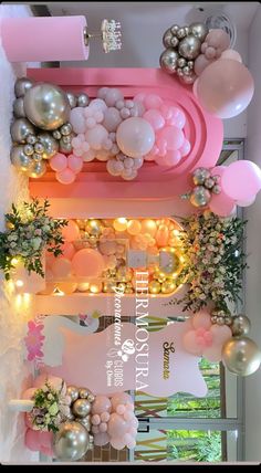 balloons and garlands are hanging from the ceiling in a room with pink, white and gold decorations