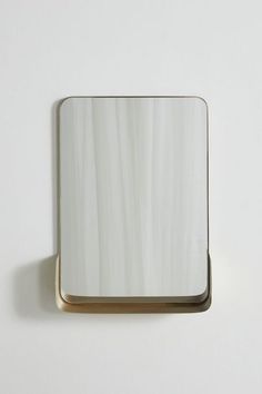 a square mirror mounted to the side of a wall