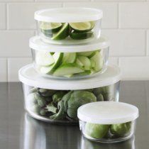 three plastic containers filled with green vegetables on top of a counter