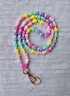 a multicolored star beaded lanyard on a white brick wall with a pair of scissors