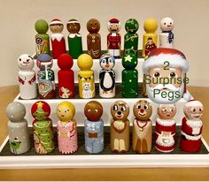 an assortment of wooden christmas figurines on a shelf in front of a wall