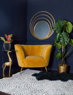 a living room with blue walls, gold accents and a round mirror on the wall