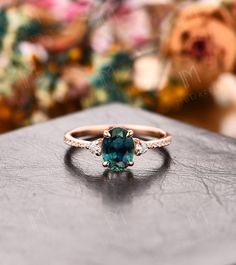 a ring with an oval cut blue diamond surrounded by small white diamonds on a table