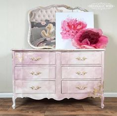 a pink dresser with flowers on top