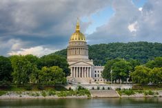 the capitol building is surrounded by trees and water