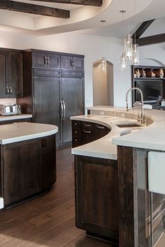 a large kitchen with an island, sink and refrigerator freezer combo in it's center