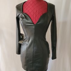 a black leather dress with red linings on the shoulders and back, worn by a woman