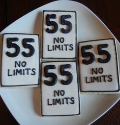 four decorated cookies on a plate with the number 55 and no limits written on them