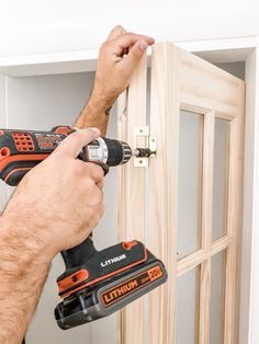 a man is using a drill to fix a door