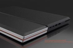 the back side of a black and silver laptop with an orange stripe on it's edge