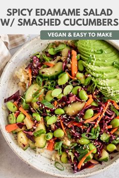 a white bowl filled with vegetables and veggies next to a sliced avocado