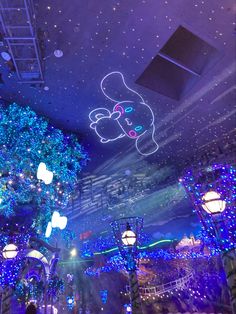 the ceiling is decorated with blue lights and white decorations, while people are standing under them