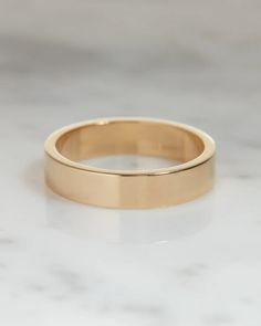 a gold wedding ring sitting on top of a white counter