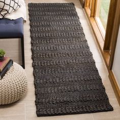 a black rug on the floor next to a window