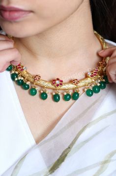 Our gold-plated hasli choker necklace is a Vintage tribal piece, with a contemporary spin on design. The traditional Indian hasli is a hand-carved work of art inspired by floral patterns. The choker delicately balances age-old craft and floral motifs encrusted with pink tourmaline stones with green agate stones hanging at the bottom along with shell pearls adding an ethnic yet contemporary touch to your style. Experience the divine allure of ancient Indian jewelry technique with this handcrafted Traditional Gold Plated Choker Necklace, Gold Cutdana Fusion Necklace, Gold Cutdana Choker Necklace, Fusion Style Gold Choker With Tilla, Gold Kundan Necklace, Fusion Style For Rituals, Gold Fusion Choker With Tilla, Gold Fusion Kundan Necklace For Rituals, Gold Fusion Choker With Tilla Detail, Gold Fusion Style Choker With Tilla