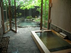 an indoor hot tub in the middle of a room with sliding glass doors leading outside