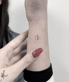 a woman's arm with a small crescent tattoo on the left side of her wrist