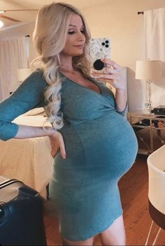 a pregnant woman taking a selfie with her cell phone