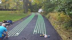 a man is working on the road in the middle of the woods with wires attached to it