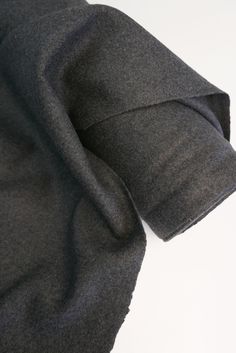 the back side of a black jacket on a white surface