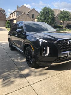 a black suv parked in front of a house