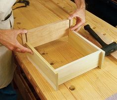 a person is working on a wooden box